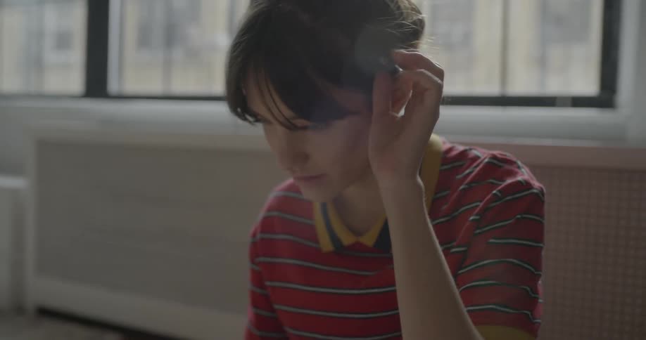 A woman takes a pen from her ear