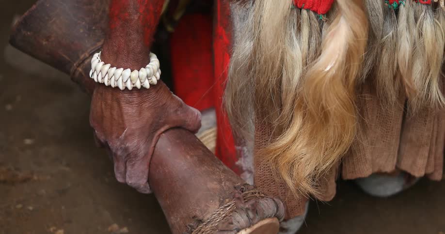 Tribesman clenching a small drum