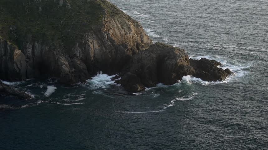 Ocean waves crash into a rocky promontory