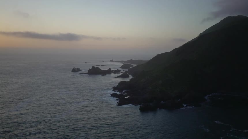 A rocky coast with the sky and clouds in the background