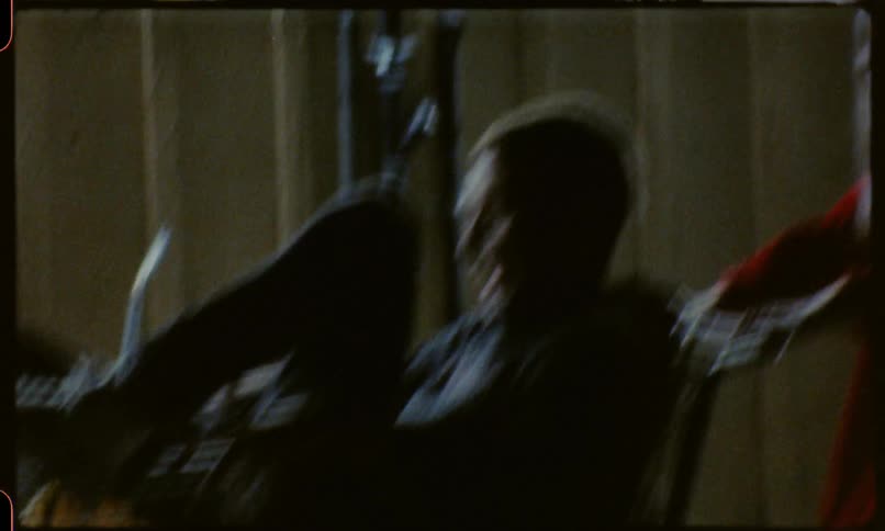 A man sitting in a trolley is pushed by someone as they both laugh