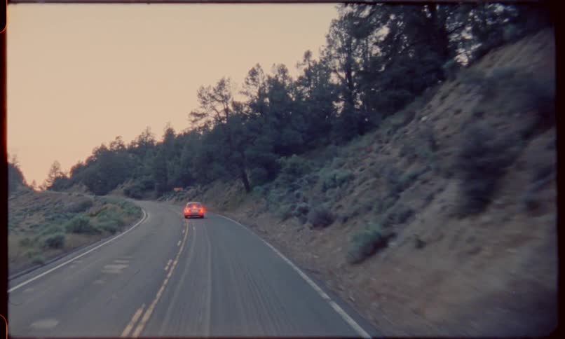 The backside of a car driving down a narrow mountain road