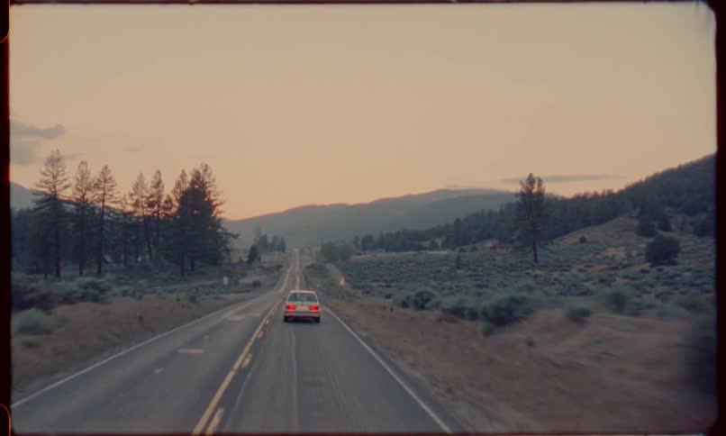 Car driving towards mountains