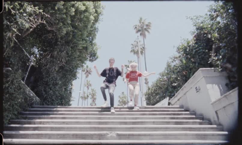 A young male and female run down an outside flight of stairs