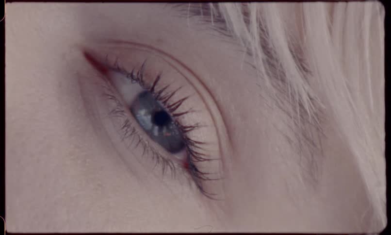 Blonde blue eyed girl opens her eye during daylight