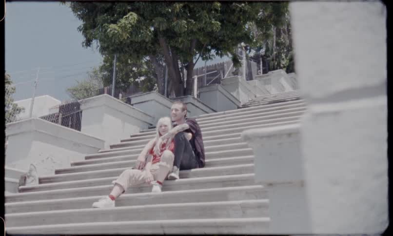 A couple sits on a large set of stairs together