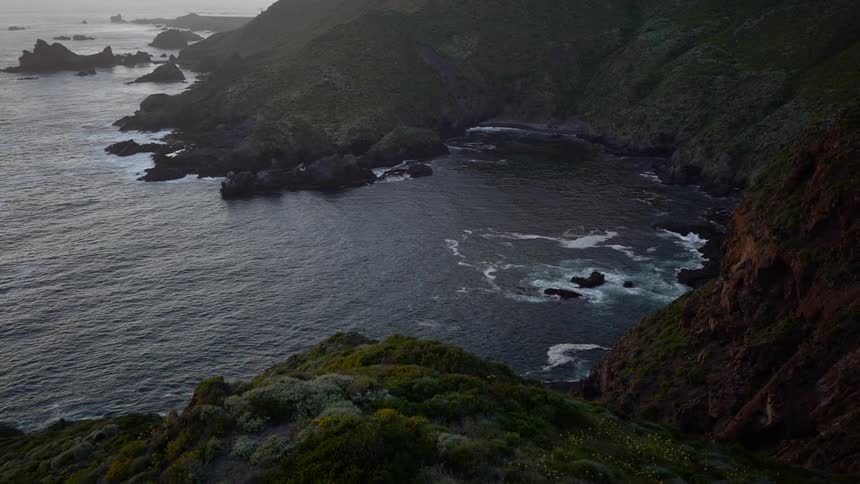 The waves are crashing against the rocky shore