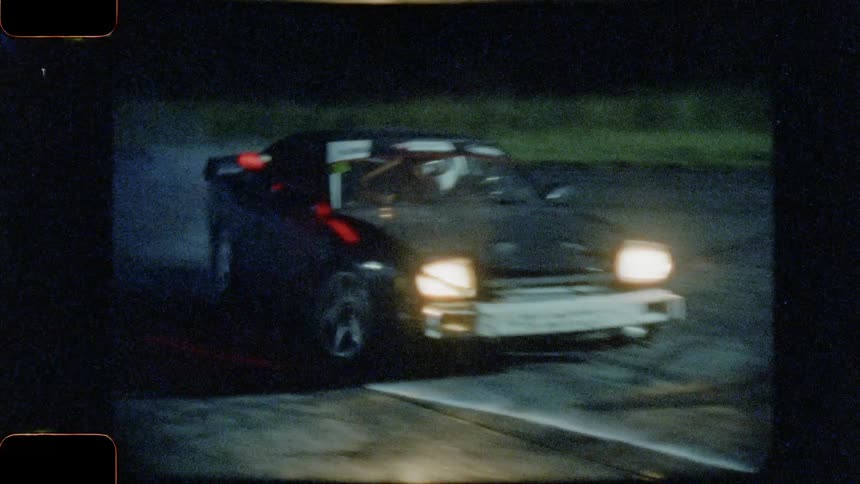 A sports car drift racing at nighttime