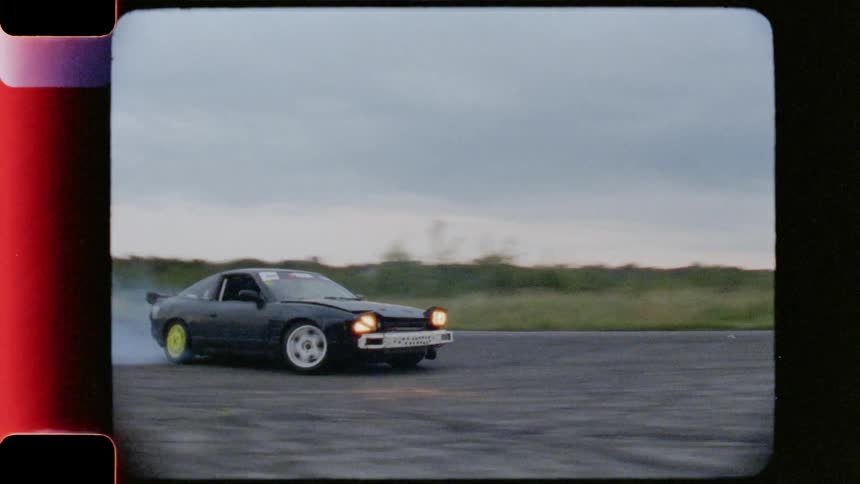 A black car drift racing at daytime