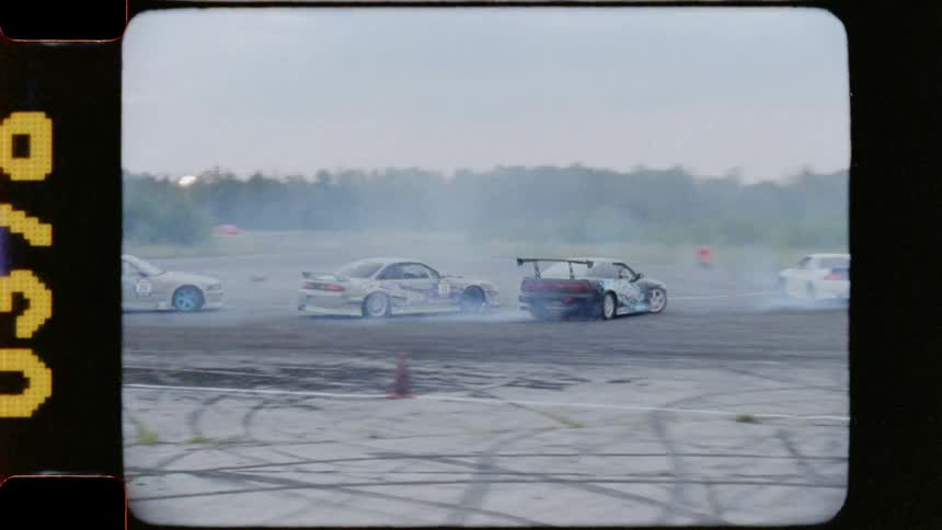 Cars drifting around the corner of an outdoor track