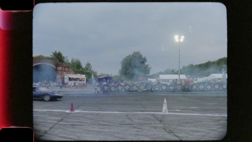 Race cars race in a drift event on a cloudy day