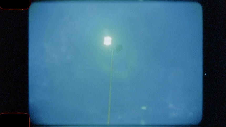 Several tall outdoor flood lights are seen against a cloudy evening sky and a quick view of an outdoor basketball hoop is shown