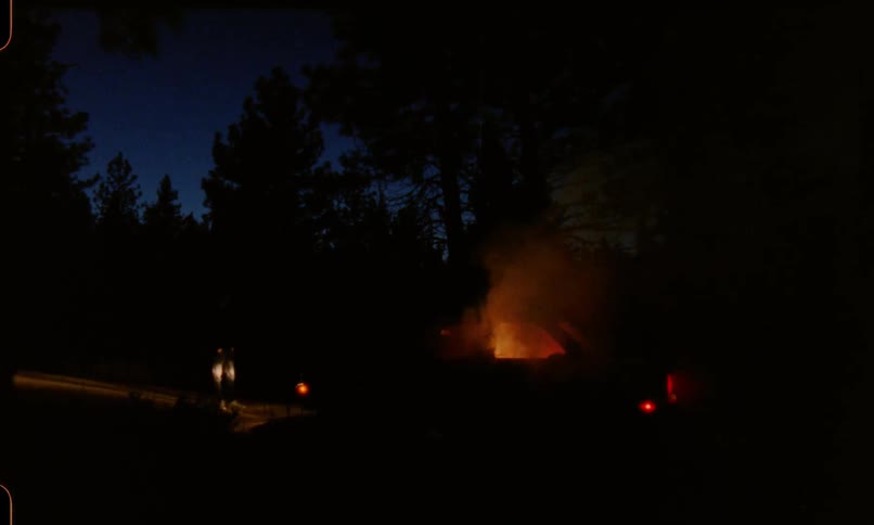 Smoking emitting from a fire burning inside a car at night