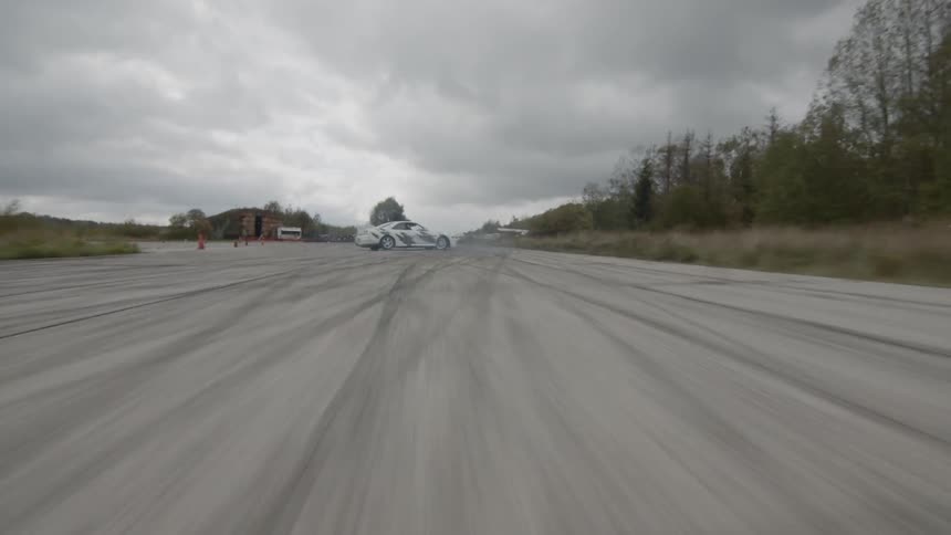 A race car spinning out on a race course before correcting itself
