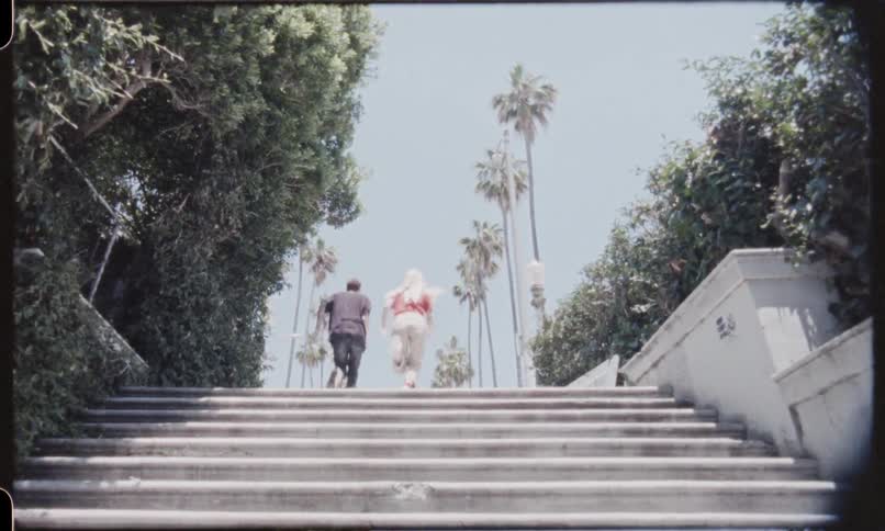 Teenage couple running up concrete stairs