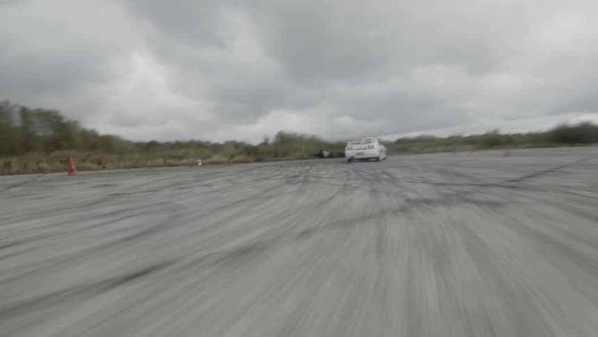 A car navigating a race course at high speed and spinning out