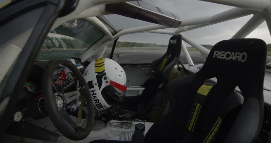 The interior of a race car with a helmet and steering wheel