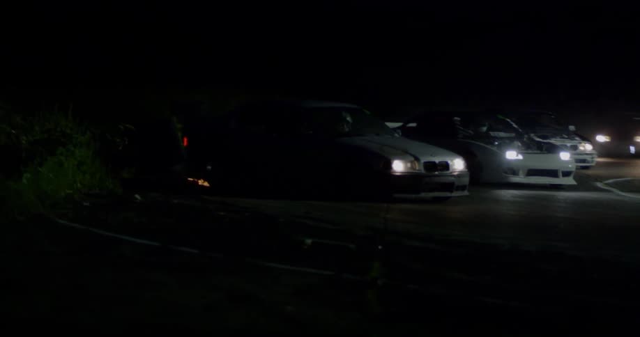 Stock cars racing around an improvised circuit at night