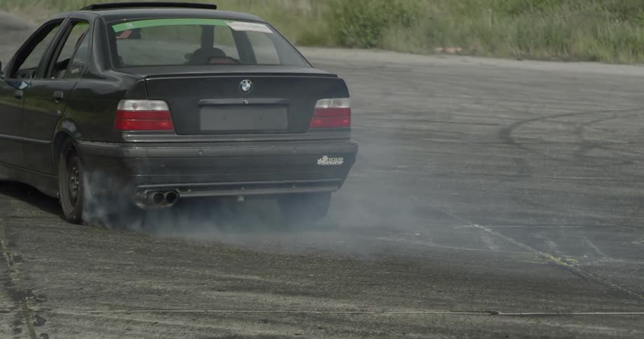 A black car drift racing at daytime