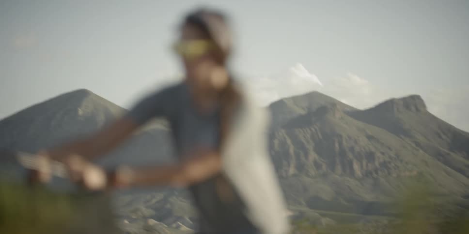 A woman out of focus while working on a tent