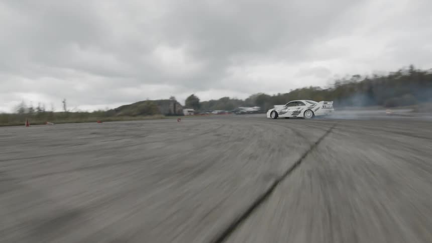 A white car drift racing at daytime