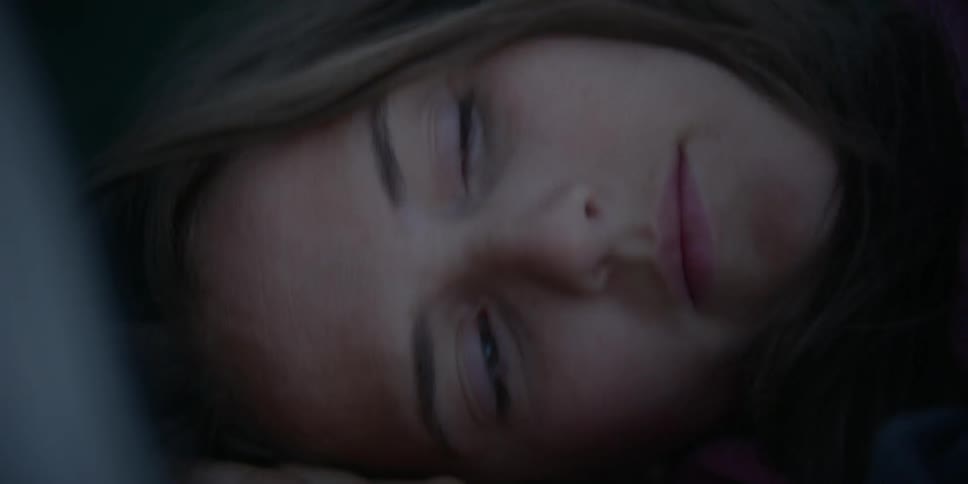 A woman sleeping in a tent wakes and sits up