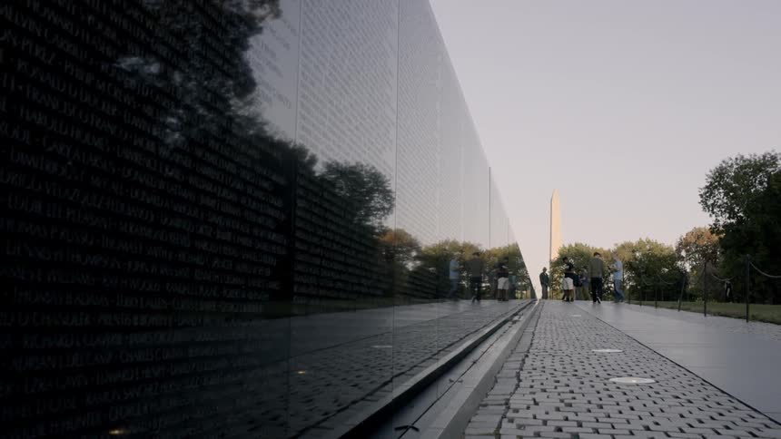 People walk next to the vietnam war memorial