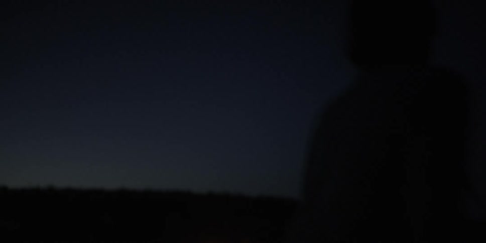 Woman gets out of tent and goes to the campfire at night