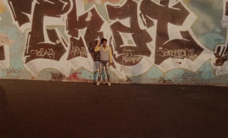 A woman standing at a wall and waving