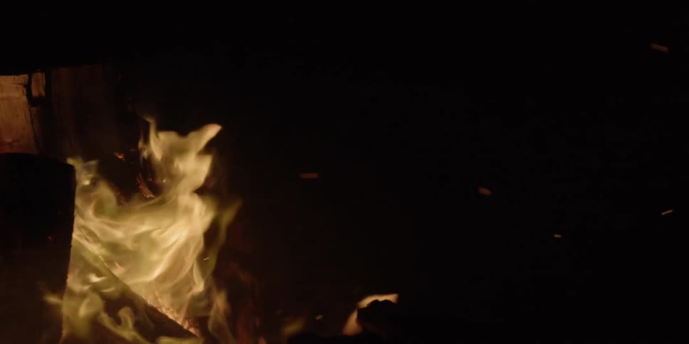 A fire burning wood at nighttime