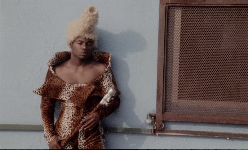 A person in costume stands next to a wall