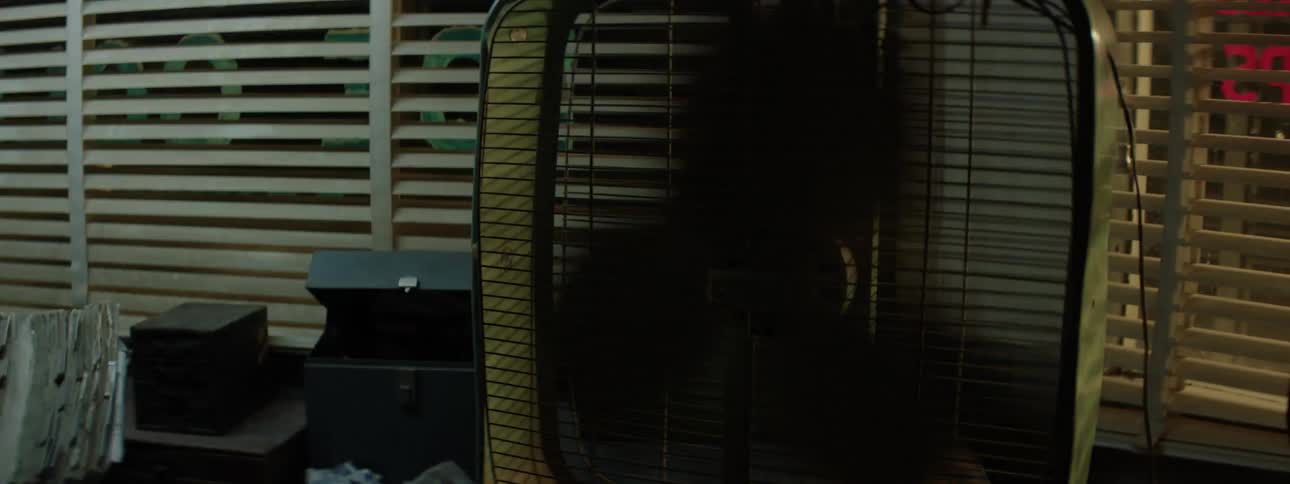An old box fan is jumping around on a table with flashing lights