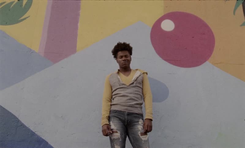A man standing in front of an artistic wall