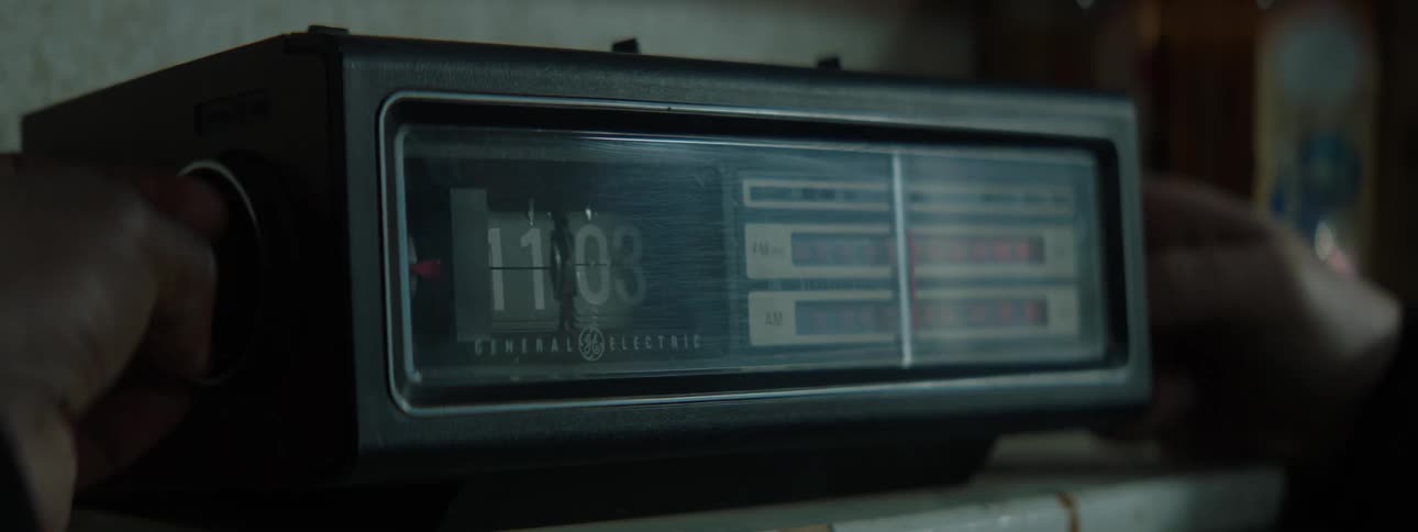 Man tunes in radio indoors during daylight