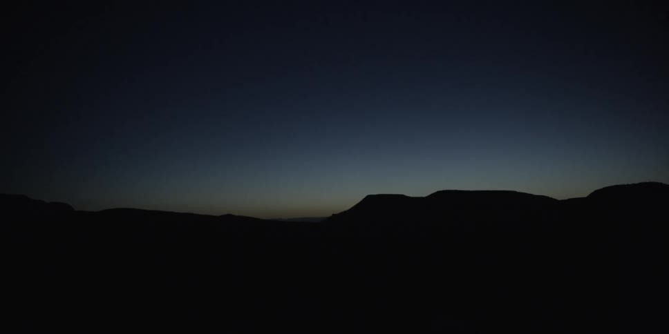 Hills in the dark with the sky in the background