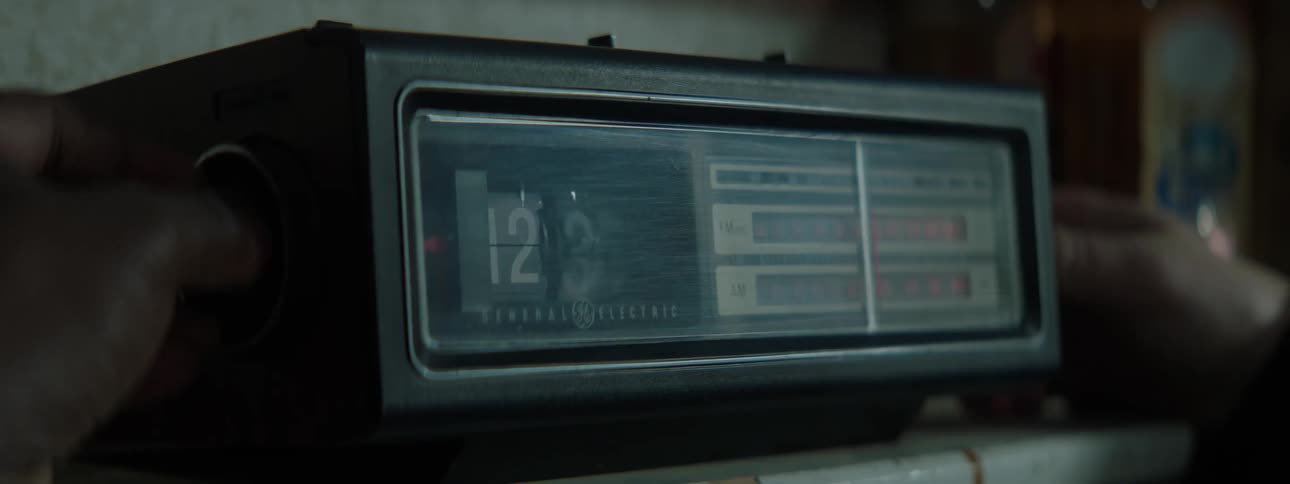 A person turns the controls on a clock radio