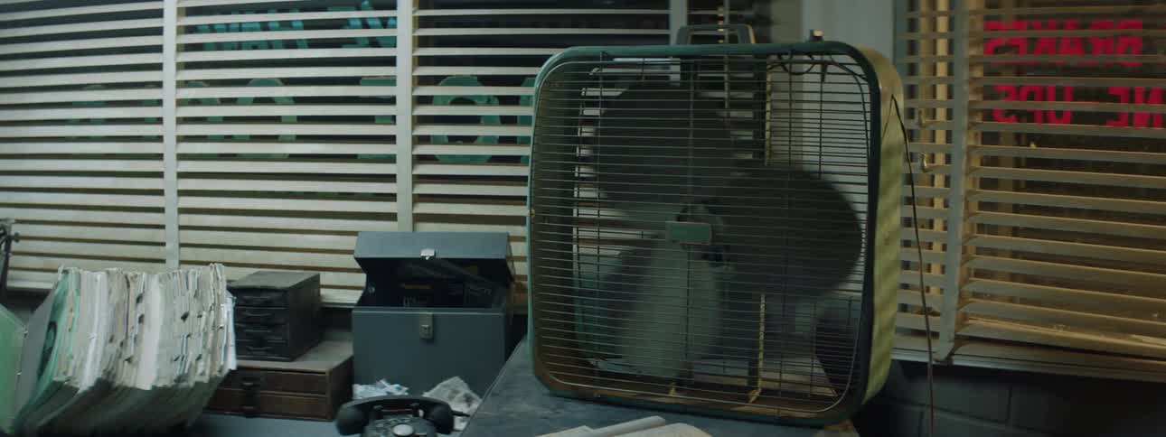 A box fan next to a window turning on