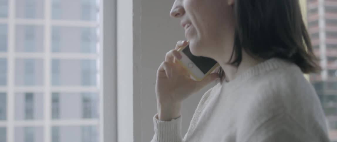 Woman talking on her smartphone ends the call and puts it down