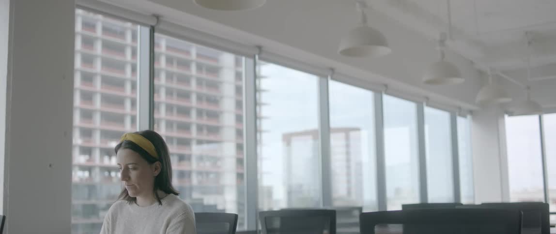 A female working on a laptop at a desk in an otherwise empty office