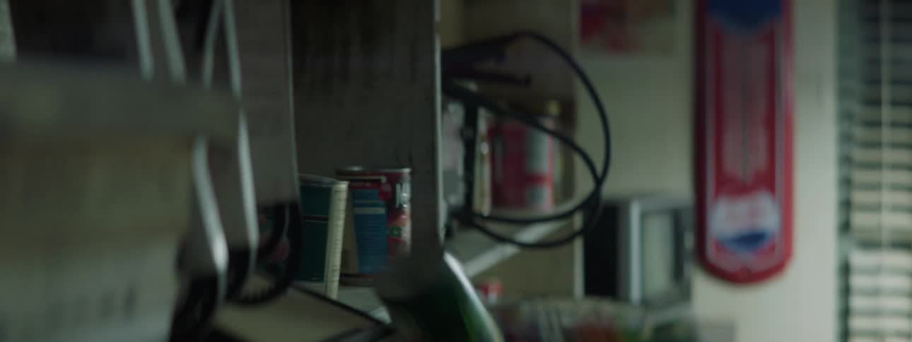 Tin cans of food falling off a shaking shelf under a blinking light