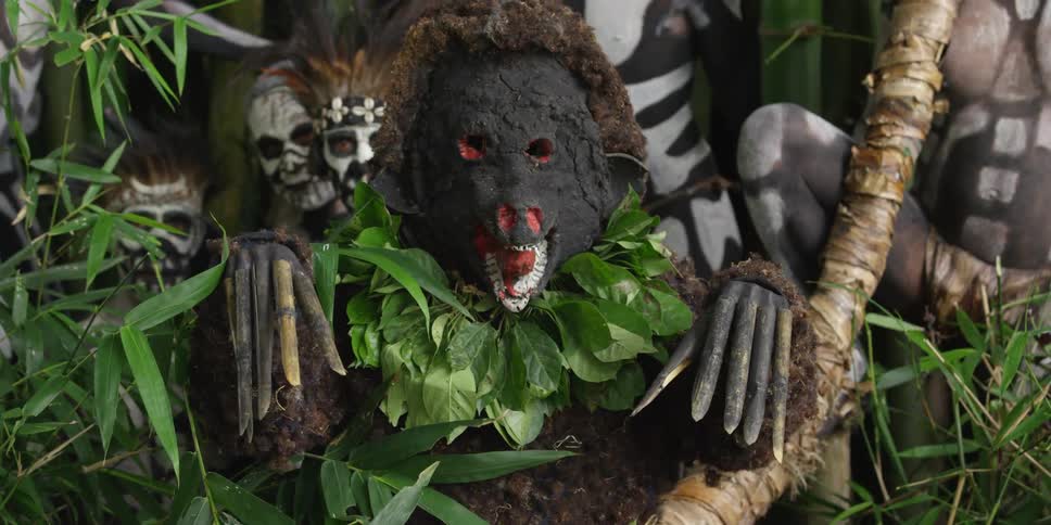 Costumed tribal man raising his claws