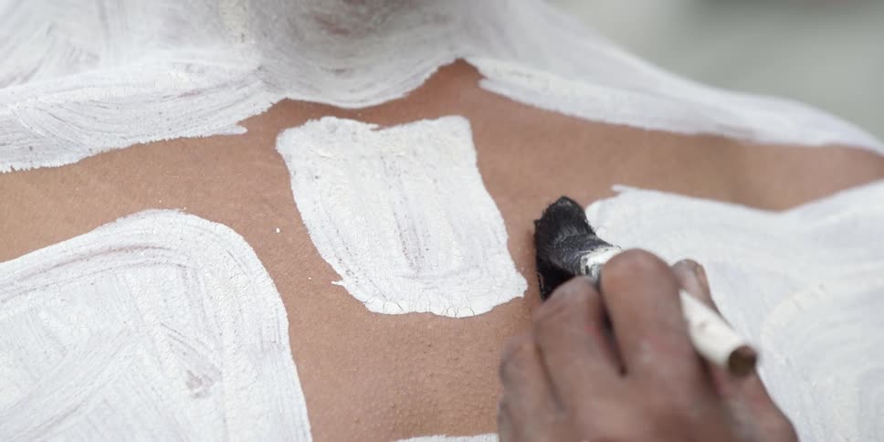 A person getting their body painted