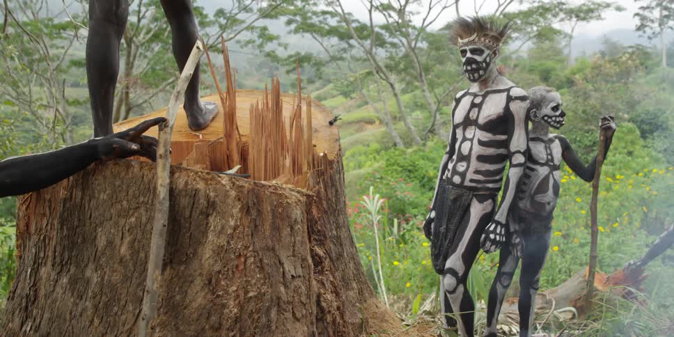 Tribal men painted like skeletons standing outside