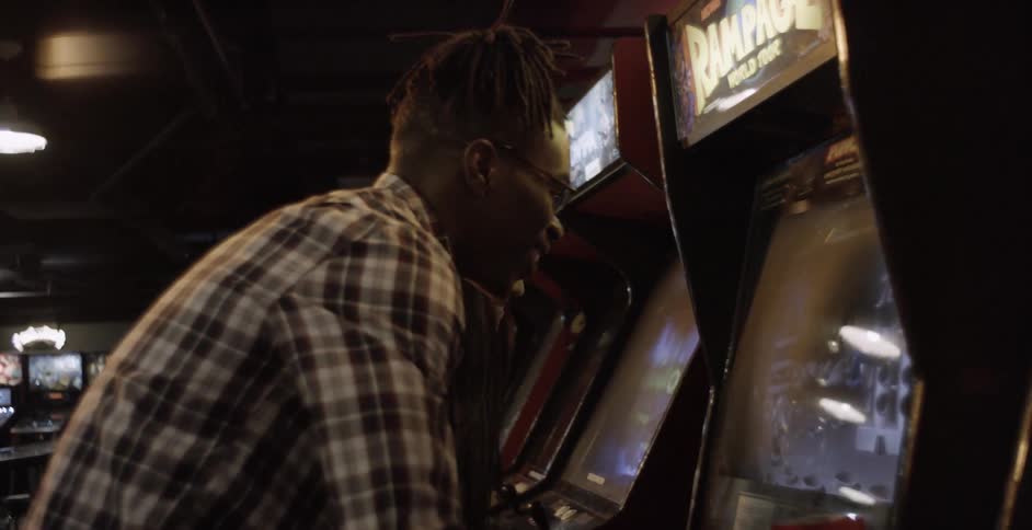 Man and woman playing video games in arcade