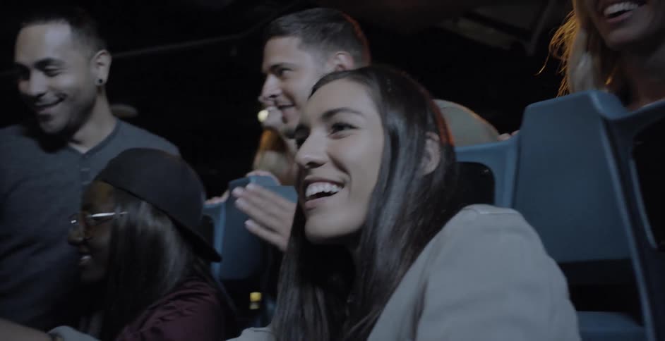 A woman plays a video game while other people watch