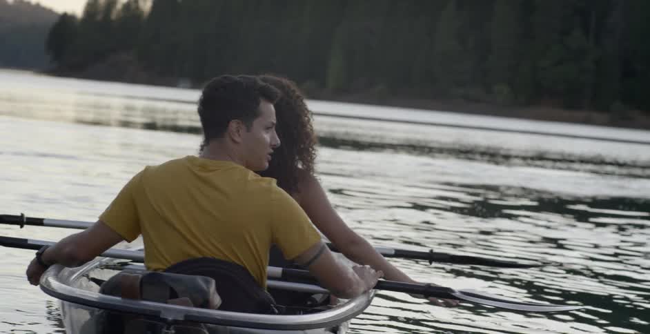 A man and woman sit in a boat and look around with neither one paddling
