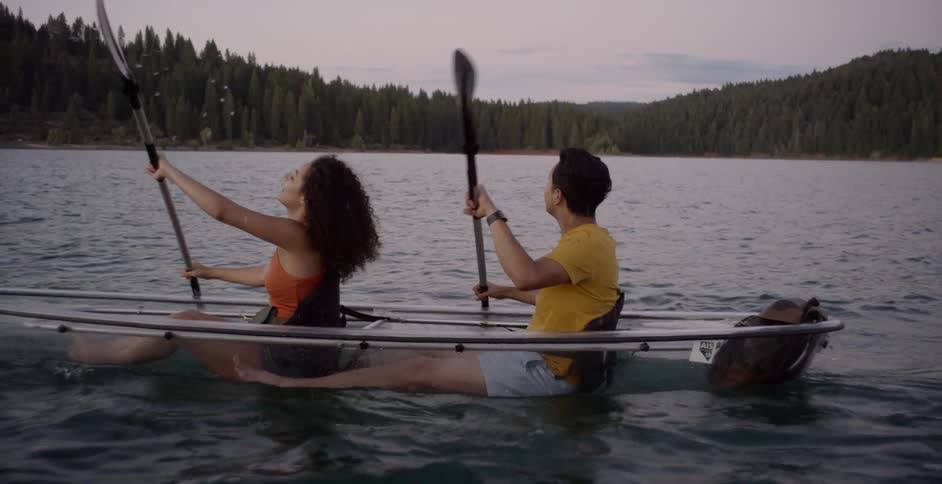 Two people row a boat together in the lake
