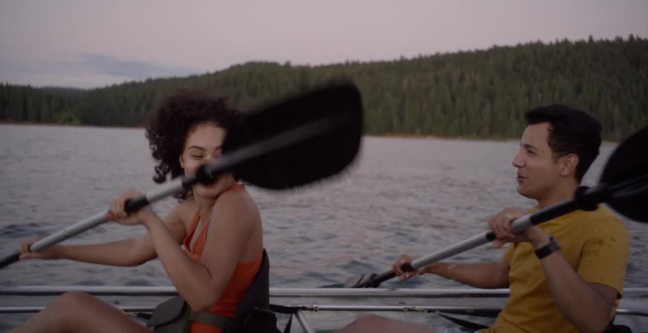 A female and a male in a rowing boat on the river paddling