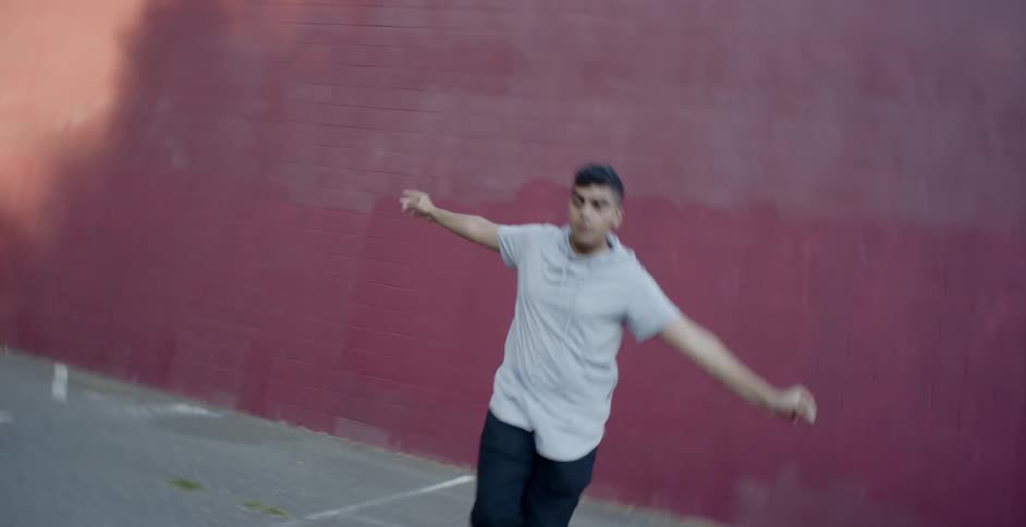 A male teenager dances outside