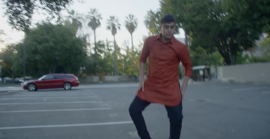 A man is dancing in the parking lot